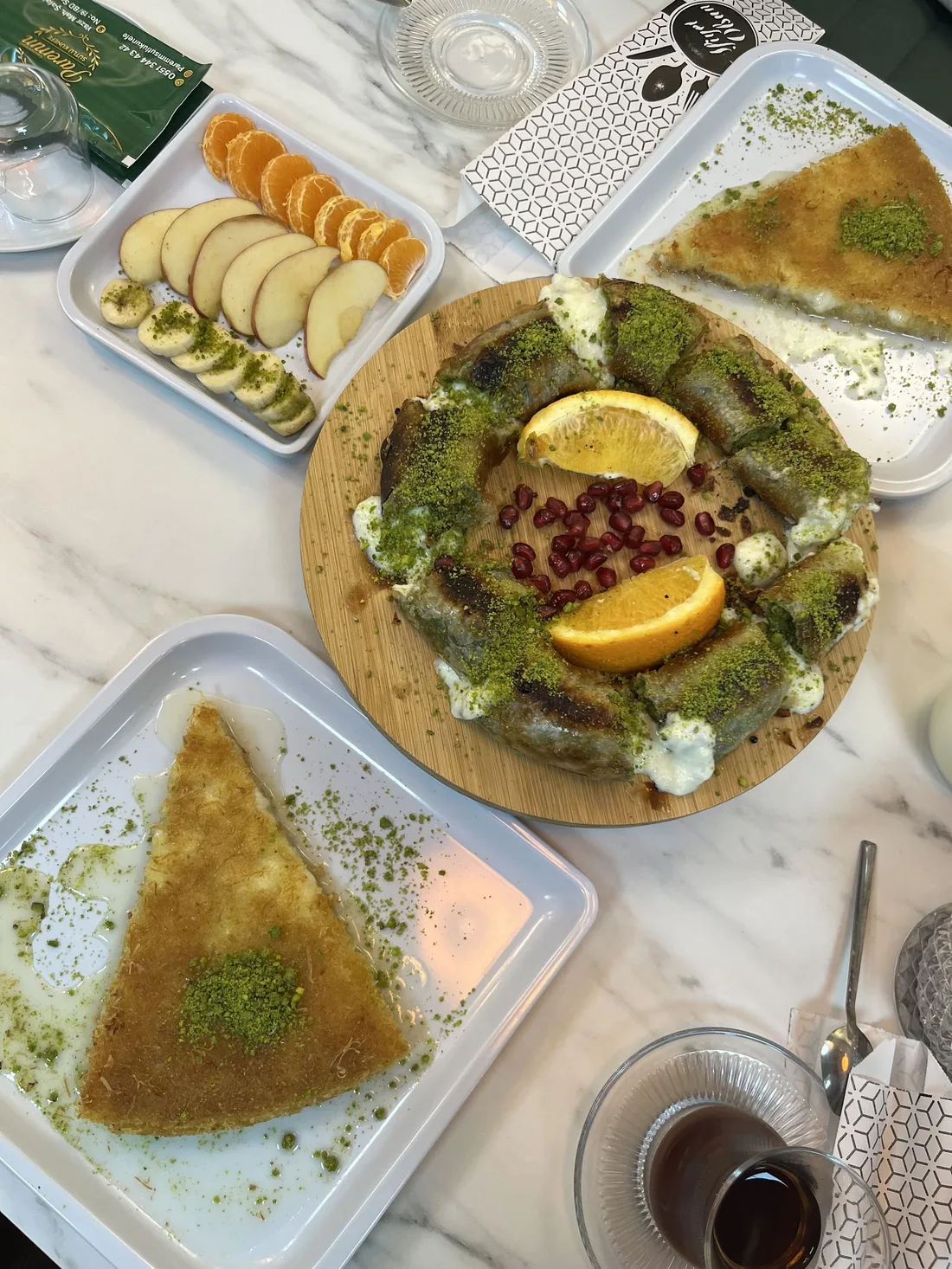 Sütlü künefe, sarma ve ikram tabaklarıyla üstten sunum